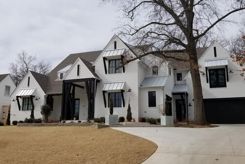 A white house with multiple Standing Seam Roofs